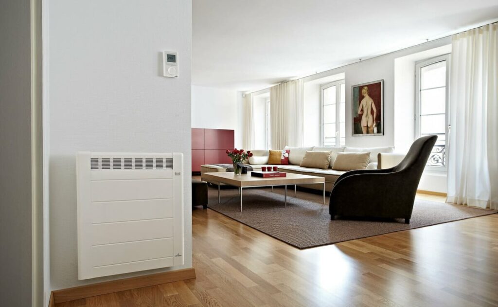 Un radiateur électrique moderne allumé dans un salon bien décoré, illustrant la consommation énergétique quotidienne.