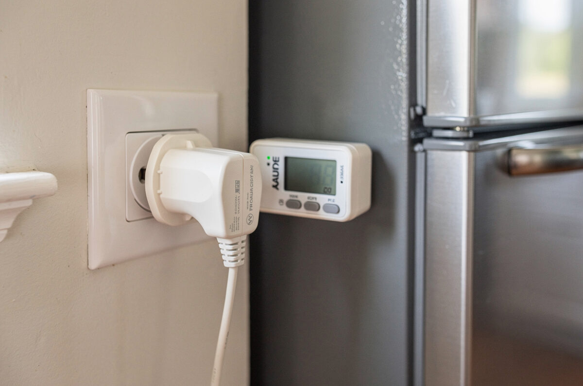 Un wattmètre de prise branché sur un réfrigérateur